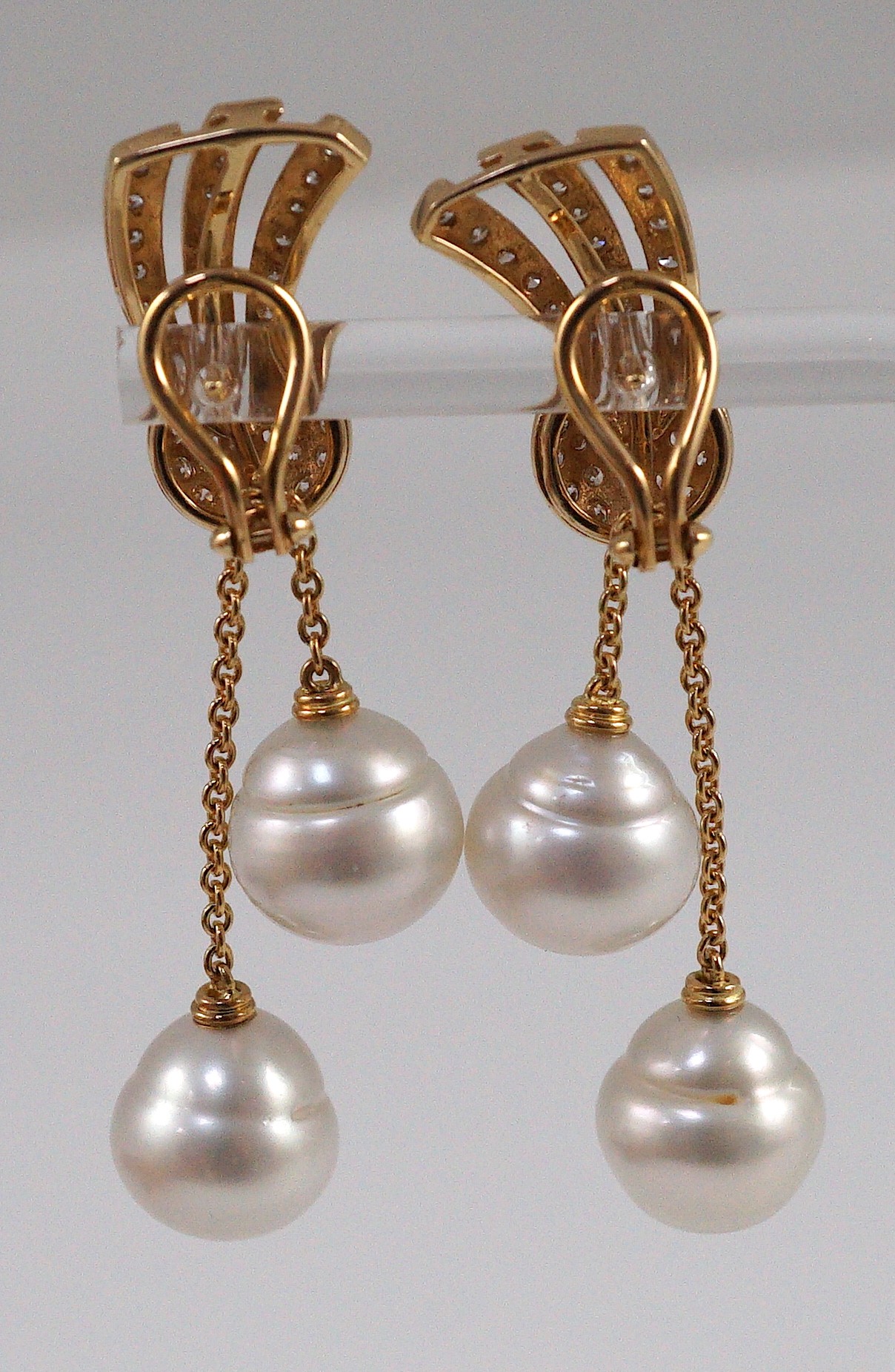 A modern pair of gold (tests as 18ct) and two stone South Sea pearl and diamond cluster set double drop earrings